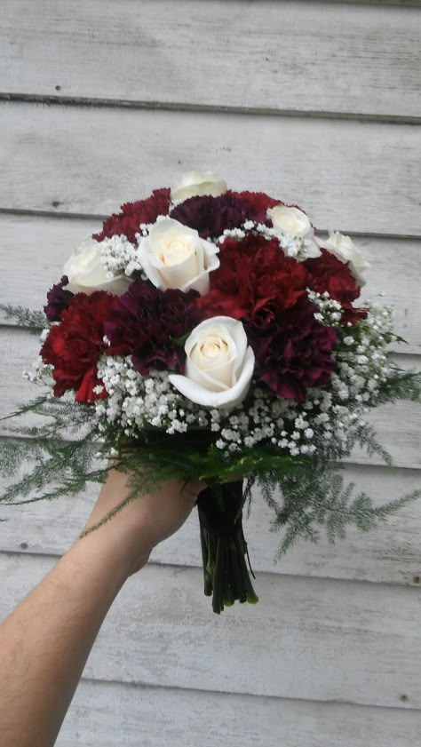 Rich colored bridal bouquet of burgundy and deep purple carnations, cream roses and baby's breath Maroon And White Flower Bouquet, Wine And White Wedding Bouquet, Sept Wedding Flowers, Colorful Mini Bouquet, Original Flower Bouquet, Wine Red Flower Bouquets, Burgundy Carnation Bouquet, Burgundy And White Bridal Bouquet, Burgundy Bride Bouquet