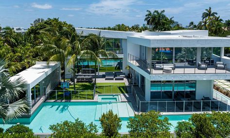 Miami Heat guard and two-time NBA All Star Victor Oladipo has listed his home on Hibiscus Island in Miami Beach for $9.995 million. The property, built in 2020, encompasses 1.5 lots and includes seven bedrooms, seven bathrooms and a guest house. The two-story home features a pool and outdoor space for entertaining and dining. The primary bedroom offers two walk-in closets and floor-to-ceiling windows overlooking the island. Hibiscus Island includes a waterfront park, tennis and basketball… Miami Waterfront Homes, Miami Beach Mansion, Miami Mansion, Victor Oladipo, Florida Mansion, Bahamas Island, Miami Real Estate, 10 Million, Island Home