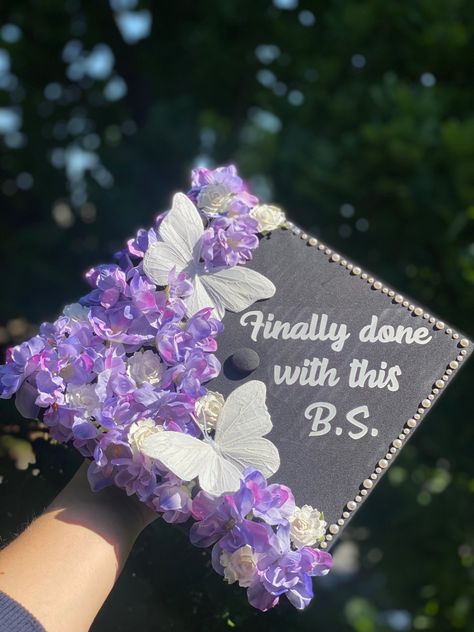 graduation cap design with purple & white flowers, white butterflies, pearls, “finally done with this BS” quote, bachelor’s of science, exercise science, kinesiology Done With This Bs, Grad Cap With Butterflies, Pearl Graduation Cap Ideas, Graduation Cap With Butterflies, Graduation Cap Designs Kinesiology, Finally Done With This Bs Graduation Cap, Cap Decoration Graduation Butterfly, Graduation Cap Designs With Butterflies, Purple Cap Decoration Graduation