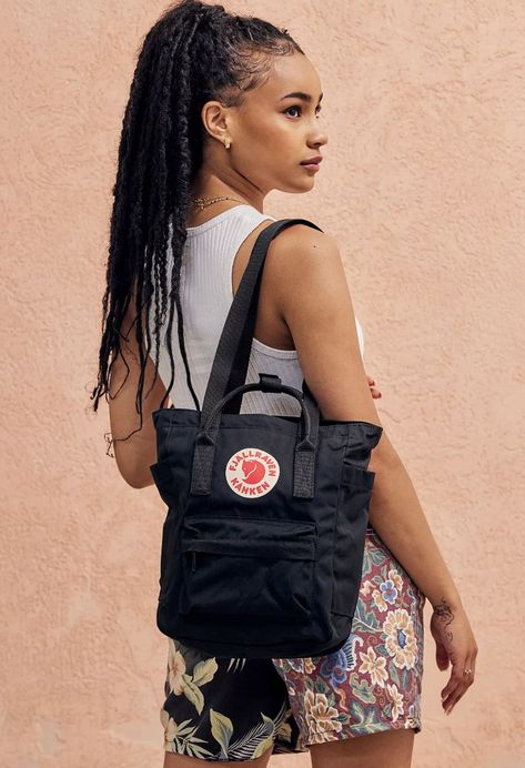 An update on the classic Kånken backpack by Fjällräven with multiple straps to carry in new ways. The Scandinavian design classic now comes with two long straps so you can wear it as a tote. Features top carry handles, a zip opening, two side pockets, zippered front pouch, adjustable backpack straps and is finished with a reflective logo badge to front. Kanken Bag Aesthetic, Kanken Totepack Aesthetic, Kanken Totepack Mini, Kanken Totepack, Fjallraven Kanken Totepack, Fjallraven Kanken No 2 Black, Fjallraven Kanken Mini Bag, Kanken No.2, Fjallraven Totepack