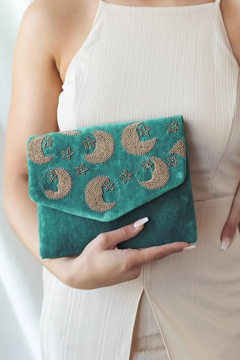 Across the Stars Teal Velvet Beaded Clutch! Low pile velvet is embellished with gold and gunmetal beading that creates a celestial pattern. Lift the top flap to reveal a magnetic closure and a lined interior with a singular sidewall pocket. Attached antiqued bronze chain strap. #velvet #beaded #clutch Fancy Clutch Purse, Whimsical Wardrobe, Celestial Pattern, Teal Purse, Canvas Bag Design, Kutch Work Designs, Beaded Pouch, Handmade Fabric Bags, Teal Velvet