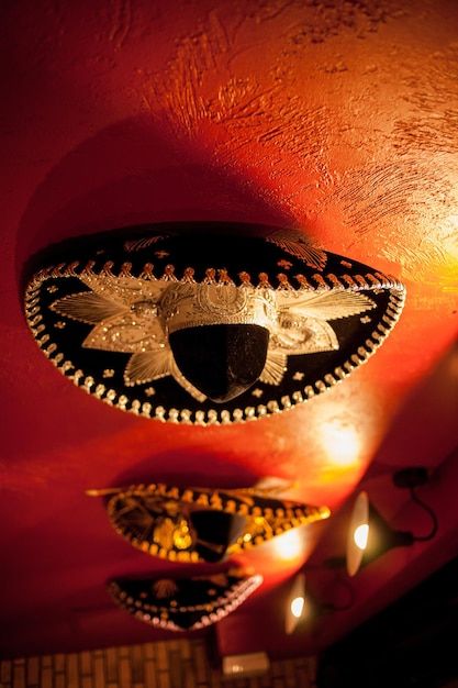 Mexican sombreros hang on the red wall, ... | Premium Photo #Freepik #photo #mariachi #mexican-hat #mexican-party #mexican-fiesta Mexican Fiesta Aesthetic, Gothic Mexican, Mexican Background, Mexican Hats, Mexican Wall Decor, Mexican Grand Prix, Mexican Sombrero, Hat Aesthetic, Mexican Hat