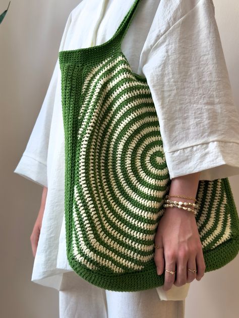 Elevate your style and embrace eco-conscious fashion with our exquisite Spiral Pattern Green and Cream Crochet Tote Bag. This meticulously handcrafted accessory is the perfect blend of functionality and elegance. The captivating spiral pattern, in shades of green and cream, adds a unique charm to your ensemble, making it a must-have for your shopping trips and beach outings. Designed with both beauty and durability in mind, this spacious tote bag is made from top-quality materials, ensuring its Crossbody Bag Crochet Pattern, Crochet Bag Border, Two Color Crochet Bag, Diy Crochet Bag Pattern, Crocheted Grocery Bags, Solid Color Crochet Projects, Chunky Crochet Purse Pattern, Funky Crochet Bag, Unique Crochet Bags