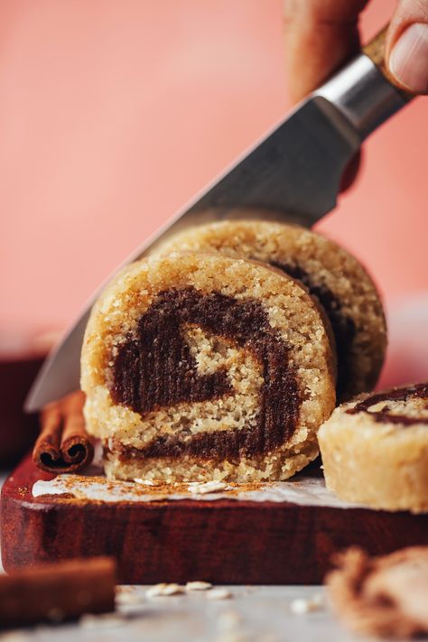 Slicing no-bake vegan cinnamon rolls Erewhon Raw Cinnamon Roll, Erewhon Cinnamon Roll Recipe, No Bake Cinnamon Rolls, Erewhon Cinnamon Roll, Raw Cinnamon Rolls, April Recipes, Cinnamon Roll Bites, Dessert Balls, Beginner Vegan