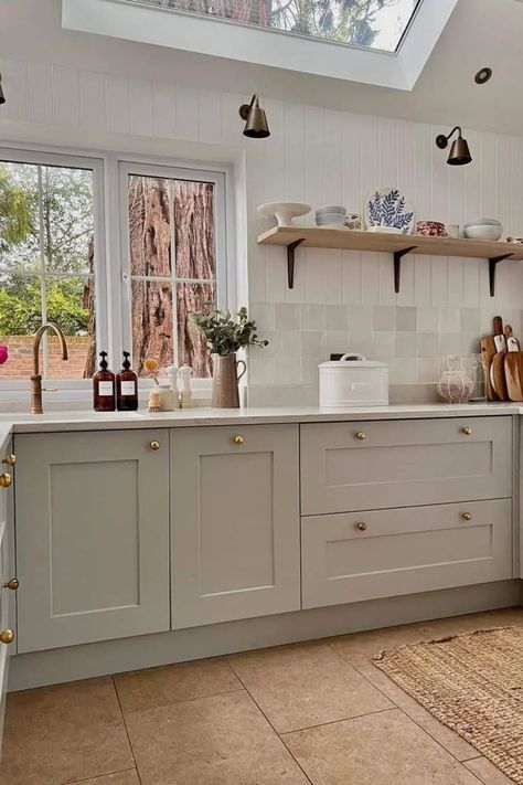 Bask in the soft radiance that fills this contemporary cottage kitchen via a heavenly skylight. Vertical shiplap and light gray square tiles cocoon the space, fostering a comforting retreat. Enhance the walls with carefully curated baskets, reflecting the charm of the woven jute rug on the beige tile floor beneath. Beige Tile Kitchen Floor, Beige Tile Kitchen, Gray Kitchen Ideas, Vertical Shiplap, Shiplap Kitchen, Farmhouse Kitchen Inspiration, Square Tiles, Farmhouse Kitchens, Beige Kitchen