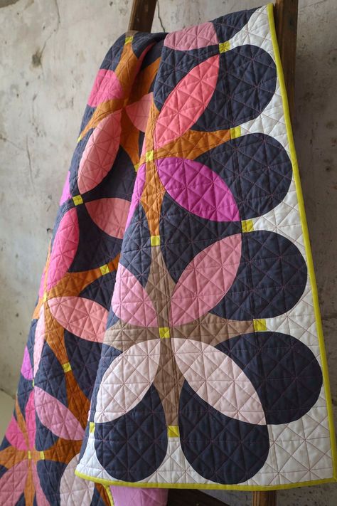 Retro Blossoms is a modern take on pieced curves with a nod to the past. This vintage floral inspired quilt has a mix and match-style color palette and three different kinds of traditionally pieced curves. Pattern includes 7 sizes: Pillow (20" x 20"), Wall Hanging (20" x 33"), Baby (47" x 47"), Table Runner (20" x 88"), Square Throw (61" x 61"), Large Throw (61” x 74") and Bed (88" x 88"). Click through to read more about the Retro Blossoms Cover quilt using Robert Kaufman Kona Solids!