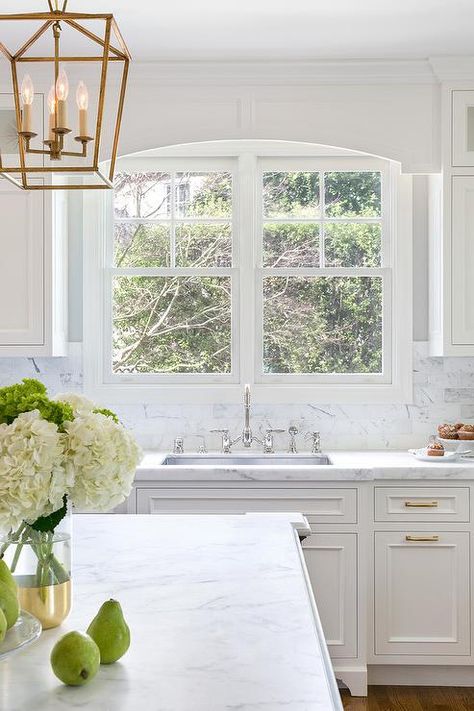 Window over a kitchen sink is dressed with a white wood cornice box matching surrounding white shaker cabinetry, moldings and window frames. Kitchen Window Box Over Sink, Kitchen Sink Window Decor, Over Kitchen Sink, Wood Cornice, Window Over Sink, Kitchen Backsplash Trends, Kitchen Window Valances, Kitchen Sink Window, Best Kitchen Sinks