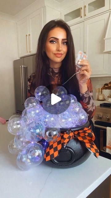 Muna Nijmeh on Instagram: "DIY BUBBLING CAULDRON!  Here is a simple and super cool DIY you can do for Halloween! Grab a plastic cauldron, and fill it up with some foam blocks. Start hot gluing some iridescent ornaments to the blocks and swooping down the side of the cauldron. I added some purple fairy lights before adding the ornaments but left slack so that I can wrap it around all the ornaments.  🧙‍♀️ SAVE THIS IDEA 🧙‍♀️  #halloweendecor #diyideas #dollartree #amazonfinds #halloweendecorations" Diy Halloween Calderon, Cauldron With Ornament Bubbles, Caldron With Bubbles, Bubble Cauldron Diy, Halloween Cauldron Diy, Bubbling Cauldron Diy, Halloween Cauldron Ideas, Cauldron Decoration Ideas, Diy Cauldron