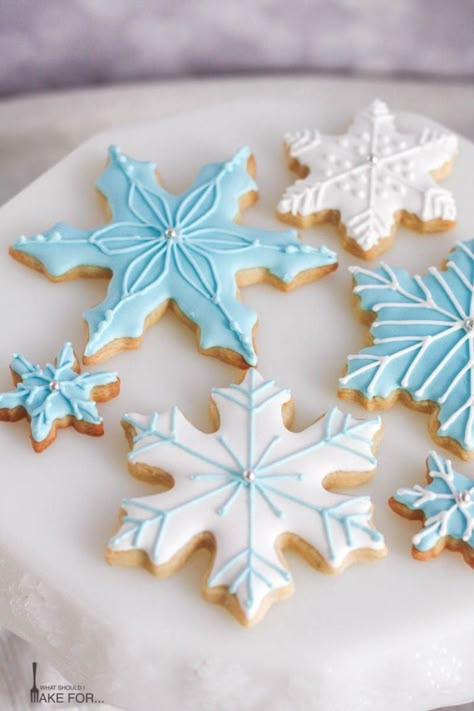 Snowflake cookies decorated with blue and white icing make a sweet holiday display. These simple cut out cookies are decorated with royal icing and will wow at your cookie exchange! Christmas Cookie Snowflake, Snow Flake Cookie Designs, Decorating Snowflake Cookies, Sugar Cookies Snowflake, Christmas Cookies Decorated Snowflake, Snow Flake Cookies Royal Icing, Snowflake Royal Icing Cookies, Snowflake Decorated Cookies, Snowflake Sugar Cookies Royal Icing