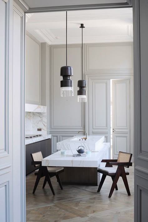 In the kitchen, all technical elements are hidden behind calacatta marble partitions. Bronze ‘Fingi’ suspension lighting by Eric Schmitt (Eric Schmitt). Office armchairs by Pierre Jeanneret (Galerie 54).  http://www.yatzer.com/joseph-dirand-saint-germain-paris // Photo © Adrien Dirand / AD France n° 119, September/October 2013. Modern French Interiors, Glamorous Kitchen, Joseph Dirand, Minimalist Dekor, Parisian Apartment, Paris Apartments, Kitchen Marble, Design Del Prodotto, French Interior