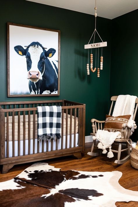 rustic nursery with wooden crib and rocking chair with cozy bedding and blankets. a coq painting on wall and wooden flooring with cow pattern rug. Montana Themed Nursery, Cowboy Themed Nursery Boys, Boy Nursery Western, Boy Room Paint Ideas, Cowboy Baby Room, Country Themed Nursery, Farmhouse Nursery Boy, Newborn Boy Nursery, Cowboy Nursery Baby Boy