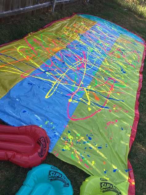 Paint slip and slide, this was so much fun for my sweet 16!! Great with white shirts  because it stains! Almost like a tie dye! Get extra to re- apply!! Just put it on and set it up like normal. Glow In The Dark Slip And Slide, Paint Wars Party Ideas, Paint Slip And Slide, Splatoon Party, Glow Party Favors, Messy Party, Sweet 16 Candy, Teenage Birthday Party, Color Wars