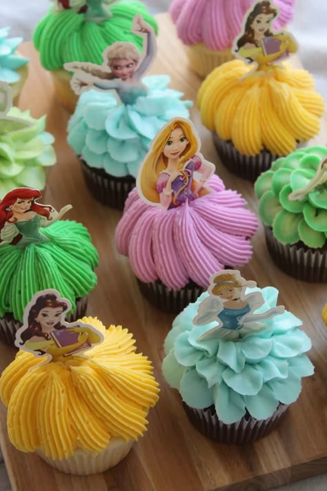 Pretty buttercream princess cupcakes piped with buttercream and topped with a princess cupcake topper!  . . #princess #princesscupcakes #cupcakes #princesstheme #disney #disneycupcakes #buttercream Disney Princesses Cupcakes, Princess Birthday Party Cupcakes, Disney Princess Birthday Cupcakes, Tangled Birthday Cupcakes, Cupcake Cakes Pull Apart Wedding, Fairytale Cupcakes Ideas, Rapunzel Cupcakes Ideas, Princess Themed Cupcakes, Princess Pull Apart Cupcakes