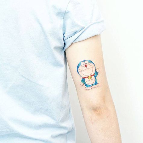 Doraemon tattoo on the back of the right arm. Doraemon Tattoo, Hello Tattoo, Books Japanese, Tattoo On The Back, Chef Tattoo, Catholic Tattoos, Ash Hair Color, World Tattoo, Japanese Manga