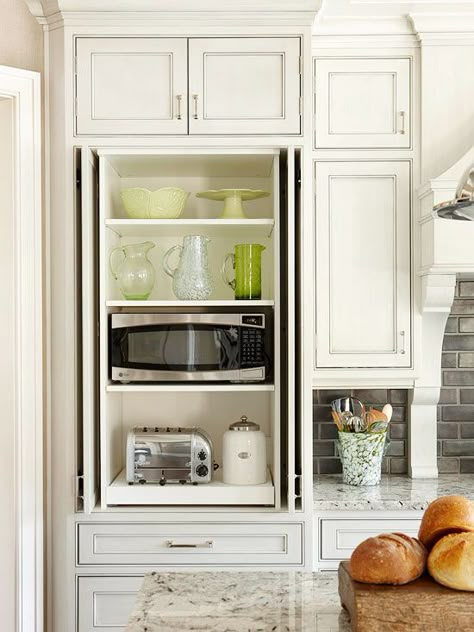 Well-planned storage organizes the large kitchen into work zones. This section of cabinetry, located right next to the range, features a toaster and microwave oven to serve as a handy breakfast pantry. Slide-out storage keeps everything within easy reach for the family's busy morning routine. Hidden Microwave, Microwave Cabinet, Kitchen Appliance Storage, Recessed Cabinet, Appliances Storage, Transitional Kitchen, Pool Design, Kitchen Redo, Trendy Kitchen