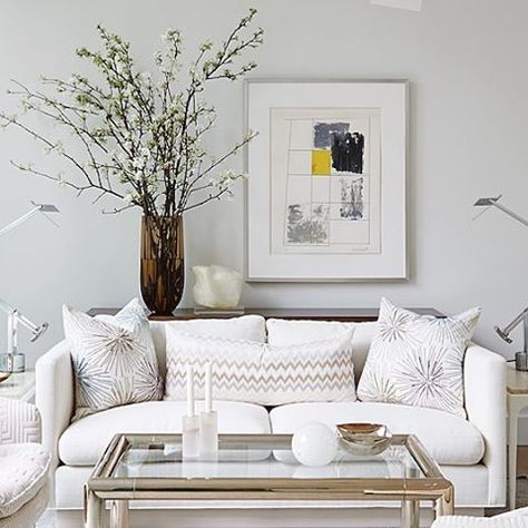 Looking for a creative way to fill the blank wall space behind your sofa? Try adding a narrow console table between the wall and your sofa, then place a tall vase on the table filled with large branches of apple or cherry blossoms and position it adjacent to a generously sized piece of art or frame. The result is whimsical and dramatic, plus it's a great alternative to a gallery wall. #AtHomeSarahStyle (photo: @staceysnaps) @simonschusterca @simonandschuster www.sarahrichardsondesign.com Console Behind Sofa, Wall Behind Sofa, Console Table Behind Sofa, Table Behind Sofa, Wall Behind Couch, Sofa Table Decor, Sarah Richardson Design, Table Behind Couch, Behind Sofa