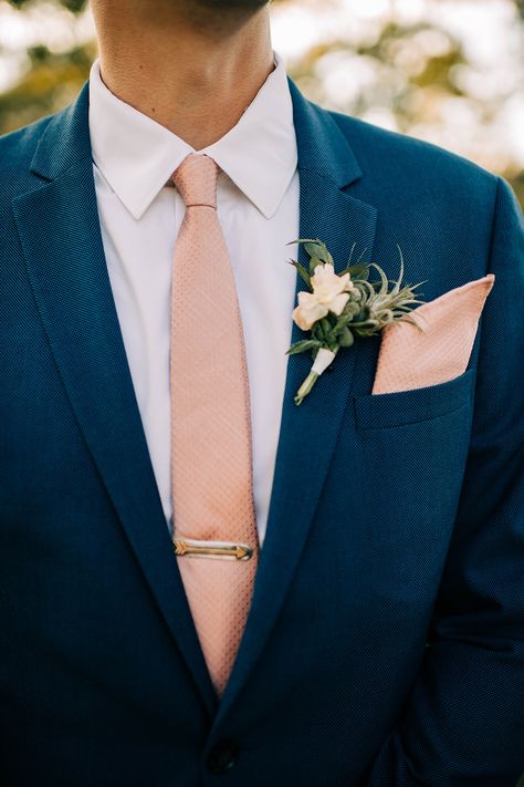 Blue suit with pink tie and tie clip - groom's attire · Rock n Roll Bride Blue Suit Peach Tie, Navy Blue And Peach Groomsmen Suits, Dark Blue Suit With Pink Tie, Groom Blue Suit Pink Tie, Navy Suit Peach Tie, Navy Blue Suit Beach Wedding, Blue Suit Pink Tie Wedding, Ties With Blue Suits, Navy Blue Suit Wedding Groom Attire Blush Pink