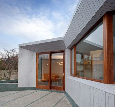 Walls reflect light into Greenlea Road extension by GKMP Architects Brick Extension, Dublin House, Exterior Wall Cladding, Vertical Siding, Glazed Brick, White Ceramic Tiles, Roof Extension, Garden Stairs, Suburban House