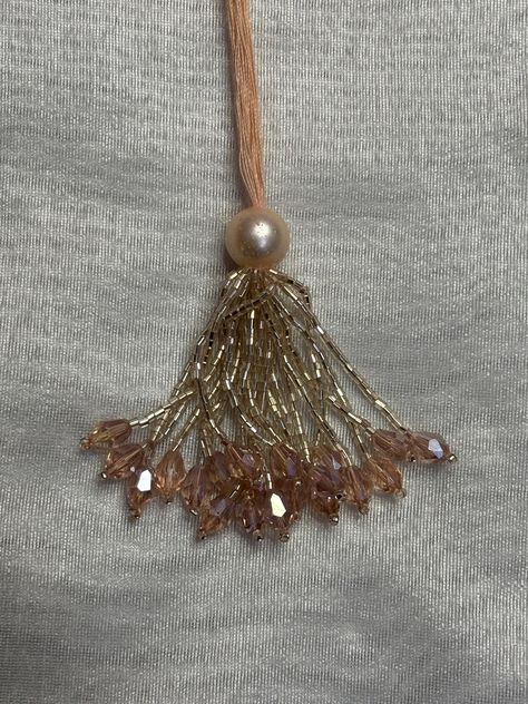 This elegant gold tassel, delicately suspended from a fine string, adds a touch of sophistication to any decor. Crafted with attention to detail, it serves as a versatile accessory for home furnishings, fashion items, or craft projects. The vibrant hue and flowing design make it an ideal choice for enhancing the aesthetic appeal of various applications Handmade Tassels For Dupatta, Latkan Designs Tassels, Dupatta Latkan, Tassels Ideas, Dupatta Tassels, Handmade Latkan, Latkan Making, Latkan Designs, Tassels Dupatta