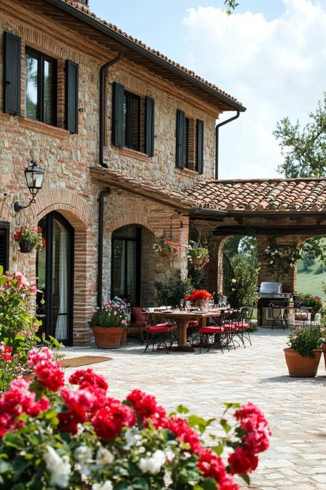 New tuscan house courtyard with flowers and dining area. Discover the timeless charm, design features, and cozy allure of Tuscan houses. Tuscan Farmhouse Exterior, Tuscan House 2000s, Small Tuscan House, Italian House Design, Tuscan House Exterior, Tuscan House Interior, Modern Tuscan House, Tuscan Landscape Design, Tuscan Houses