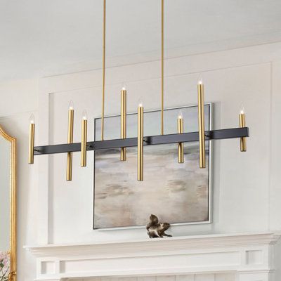 Simple and elegant, this linear chandelier features a sturdy metal frame in brushed gold and matte black finish. Two downrods suspend from the rectangular canopy to fix seamlessly with the lamp body, which features a clean-lined supporting base with 8 asymmetric candle-like arms in diverse sizes, which is a renovation of the traditional one. Plus, with no lampshades, it allows you to showcase your choice of bulbs. Finish: Matte Black/Gold | Mercer41 Trivon 8 - Light Dimmable Linear Kitchen Islan Rectangle Table Light Fixture, Dining Room Linear Lighting, Rectangle Chandelier Over Kitchen Island, Long Dining Table Chandelier, Linear Chandelier Dining Room Modern, Black And Gold Kitchen Lighting, Kitchen And Dining Lighting Combinations, Black And Gold Chandelier Dining Room, Modern Lighting Dining Room