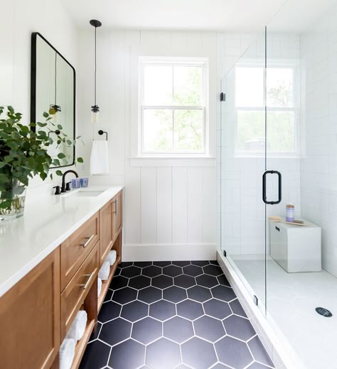 Can we talk about how gorgeous this bathroom is? We love the combination of white walls, black hex tiles and wood cabinetry! For more hexagon tile inspiration head to the website.  Design by @lillygianikas. Photo by @rubyandpeachphoto. Design Interior Baie, Makeover Kamar Mandi, Bilik Air, Apartment Decoration, Decor Baie, Master Bath Remodel, Tiles Design, Upstairs Bathrooms, Bathroom Redo