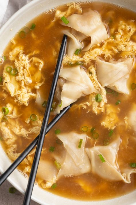 Savory and satisfying wonton egg drop soup combines two popular Chinese soups into one delicious dish. With mostly-homemade wontons, a flavorful broth, and ribbons of eggs, this easy-to-make soup is every bit as filling as it is appealing. A scrumptious main course, or the perfect appetizer for a night of takeout-inspired favorites. Egg Drop Wonton Soup Recipe, Greek Chicken Meatballs, Homemade Egg Drop Soup, Gut Food, Peach Pork Chops, 40 Aprons, Best Risotto, Wonton Soup Recipe, Chinese Soups