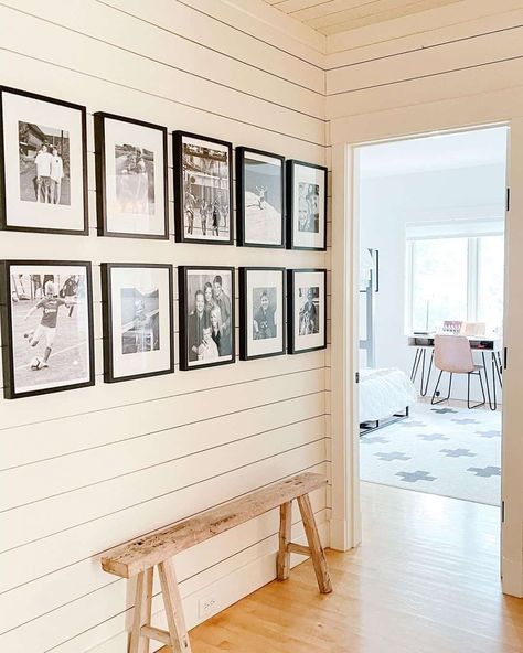 Gallery walls can fill your space with a personalized appearance only possible through custom accents. A series of black and white photos in black frames will direct attention to the white shiplap wall they are displayed on. With a small wooden bench placed before the wall, you will have a place to sit and marvel at your creation. Hall Decorating Ideas, Small Wooden Bench, White Hallway, White Wainscoting, White Shiplap Wall, Rustic Entryway, Shiplap Wall, Wooden Console Table, Console Table Hallway