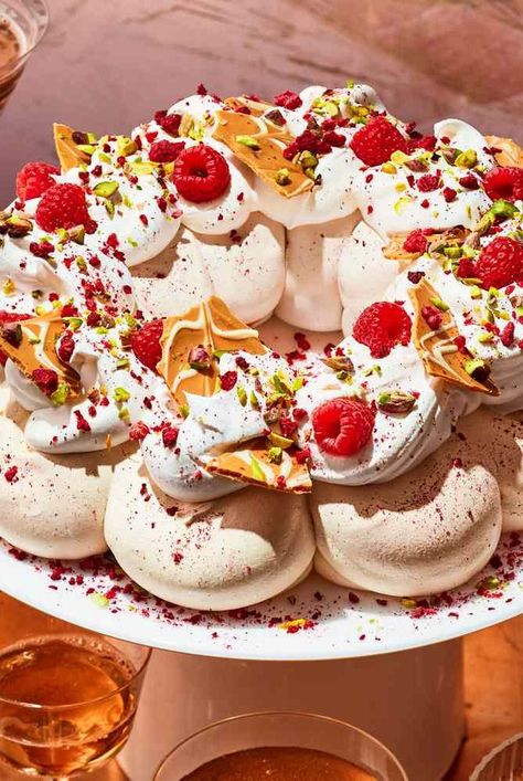 This stunning Pavlova with Caramelized White Chocolate Bark from cookbook author Kristina Cho is shaped like a wreath and topped with crumbled freeze-dried red raspberries and bright green chopped pistachios for a festive holiday dessert presentation. Amazing Christmas Desserts, Pavlova Wreath, Boiled Fruit Cake, Festive Holiday Desserts, Chocolate Peppermint Brownies, Chocolate Pavlova, Lemon Curd Cake, Caramelized White Chocolate, Caramel Pears