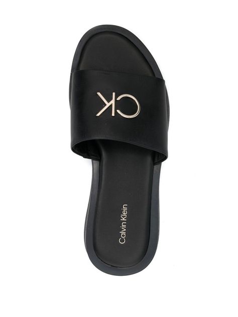 logo-plaque detail pool slides from CALVIN KLEIN featuring slip-on style, jet black, leather, logo plaque, open toe and flat rubber sole. | Calvin Klein Logo-Plaque Detail Pool Slides Luxury Modern Slip-on Slides, Black Slides With Logo, Luxury Black Slip-on Slides, Designer Black Slides With Buckle Closure, Luxury Black Slides With Buckle Closure, Designer Flip Flops, Slides For Women, Leather Logo, Pool Slides