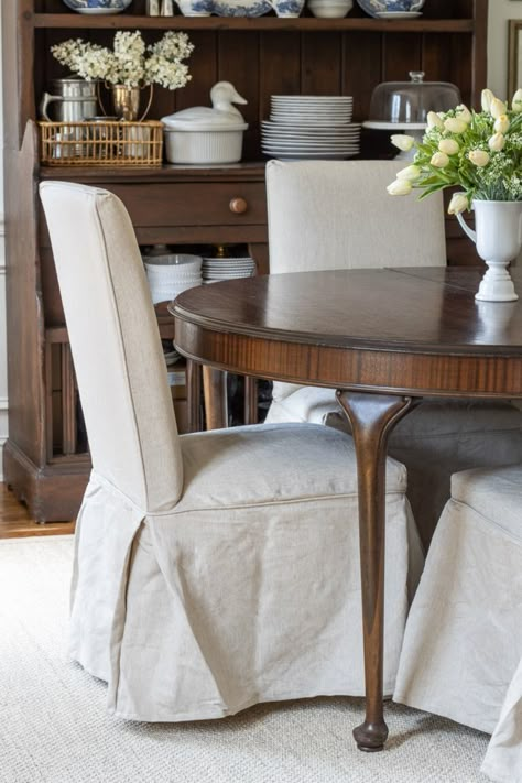 Cozy Dining Room Update Benjamin Moore Trim Color, Slipcovered Dining Chairs, Rug Mirror, Diy Chair Covers, New Dining Table, Dining Room Chair Slipcovers, Cozy Dining Room, White Dining Room Chairs, Red Dining Room