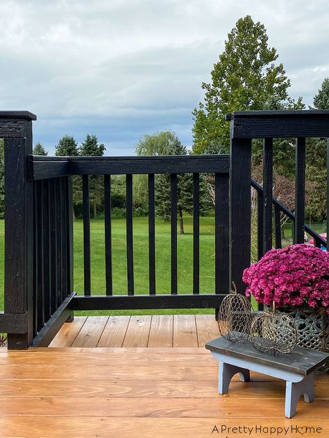 Our deck with black railing is finally done and we love it! Deck With Black Railing Ideas, Black Painted Deck Railing, Black Wood Deck Railing, Stained Deck Black Railing, Black Deck Paint, Black Spindles Wood Railing Deck, Stained Deck Painted Railing, Wood Deck Black Railings, Black Patio Railing