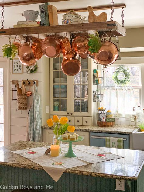 Farmhouse style kitchen with diy pot rack andspring decor - www.goldenboysandme.com Pot And Pan Ceiling Rack, Ladder Pot Rack Rustic, Pot And Pan Hanger Ceilings, Ceiling Pan Rack, Kitchen Pot Hanger Ideas, Hanging Pot Rack Decorating Ideas, Ceiling Rack Kitchen, Kitchen Pot Rack Ideas, Farmhouse Pot Rack