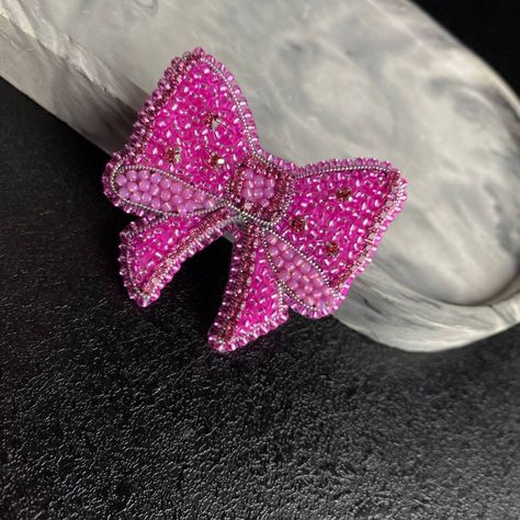 The unique "Bow" brooch is a handmade creation that will make you shine at any event! 💖  Made from high quality beads combined with shining rhinestones and embroidery wire, it will give your look a unique charm and shine. 🌟 🌿 For those who value ethics, vegan leather is used on the back, making this accessory not only stylish, but also in line with your principles. 🍃 🎁 Give yourself or a loved one a handmade masterpiece! This brooch is an excellent choice for those who value quality and ori Unique Pink Brooches As A Gift, Unique Handmade Pink Brooches, Beaded Pins, Pink Crystal Brooch Jewelry, Crystal Brooch Pink, Handmade Heart-shaped Valentine's Day Brooches, Unique Bows, Beaded Charms, Bow Brooch