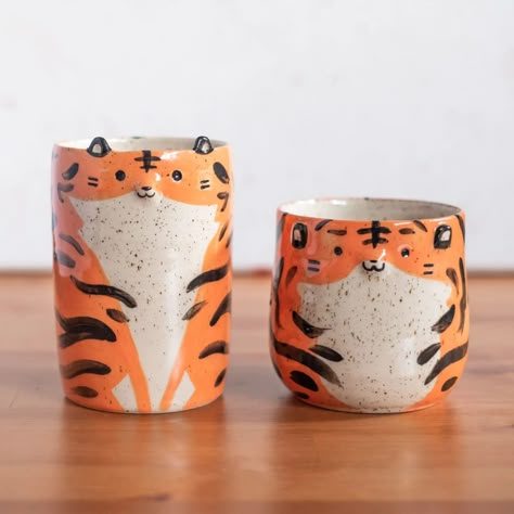 Remember these two tigers? Well, they're still looking for homes 💕 During my last shop pottery update, someone ordered both of them but then cancelled leaving them homeless and still waiting on my shelves. My next ceramics restock will include other pieces like these that didn't make it into past updates. So while there will be mainly dragons, you can expect a few of my other designs to make an appearance too 🔥 #potterylove #ceramicart #tigers Tiger Pottery, Clay Dish Ideas, Tiger Ceramic, Shop Pottery, Two Tigers, Ceramic Inspiration, Story Art, Handmade Cups, Cute Tigers