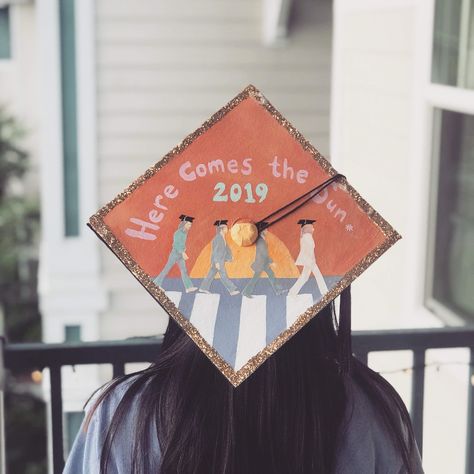 A girl with dark hair wearing a graduation cap. She is facing away from the camera. On the cap, the Beatles are walking across a crosswalk with tiny grad caps on. Above them it says Here comes the sun in an arch shape. Under that it says 2019. Senior Year Fun, Grad Cap Decorated, High School Graduation Cap, Grad Cap Designs, Grad Caps, Graduation Cap Designs, Graduation Cap Decoration, Cap Decorations, Cap Designs