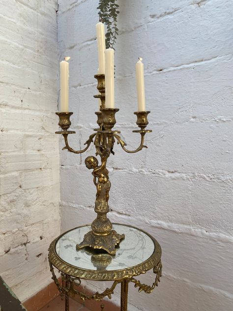 This antique French candelabra is a stunning piece of furniture that will add a touch of elegance to any room. The candelabra is handmade and original, manufactured in France or Spain. Measuring 18 inches in height and 10.5 inches in width, it is suitable for use as a table centerpiece or in an entryway, foyer, living room, lounge, or dining room. The candelabra is in a Louis XV style and features a cherub subject, making it a perfect addition to any decorative collectibles collection. It is an Candleabras Dining Table, Candelabra Decor, Candelabra Lamp, French Candlesticks, Botanical Aesthetic, Candelabra Centerpiece, Foyer Living Room, Dark Botanical, Living Room Lounge