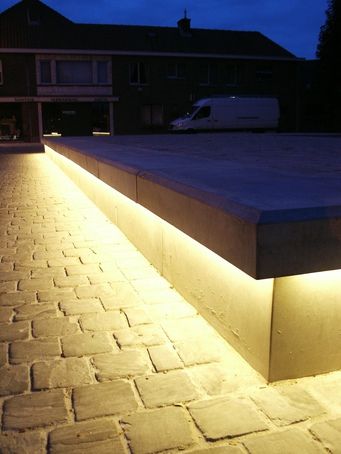 Urbastyle provided benches with integral LED strip lighting for Balgerhoeke village square near Ghent in Belgium. By day, the square is bordered with concrete benches while, by night, the integrated lighting highlights the architectural reliefs and illuminates the space... Bench Lighting, Concrete Benches, Exterior Handrail, Handrail Lighting, Exterior Lighting Design, Lighting Architecture, Lighting Exterior, Lighting Design Inspiration, Village Square