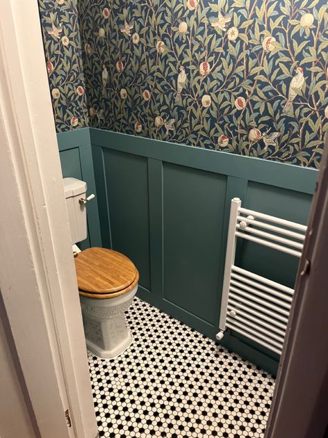 Room with toilet, green:blue panelled walls and William Morris print wallpaper with pomegranate and bird pattern. William Morris Toilet, William Morris Wallpaper Toilet, William Morris Downstairs Loo, Downstairs Toilet Ideas Small Quirky, William Morris Cloakroom, Downstairs Toilet Paint Ideas, Tiny Toilet Room Ideas Wallpaper, Tiny Cloakroom Toilet, Small Toilet Wallpaper