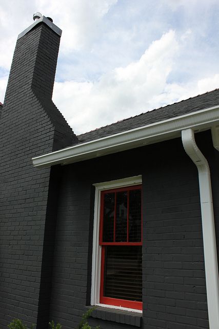 painting exterior brick  | Love this color scheme - charcoal, white and red. Black Brick Chimney Exterior, Black Chimney Exterior, Painted Chimney Exterior, Painted Brick Chimney Exterior, Exterior Chimney Makeover, Tv Mantel Decorating Ideas, Chimney Makeover, Painting Exterior Brick, Mantle With Tv Decorating Ideas