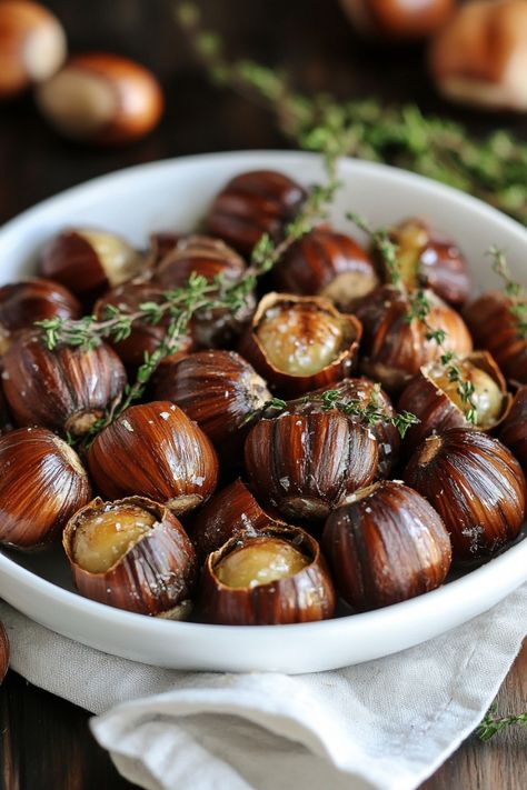 Roasted chestnuts garnished with fresh thyme in a white bowl. Roasting Chestnuts In Oven, Roasted Chestnuts Oven, Holiday Side Dishes Christmas, Spiced Hot Chocolate Recipe, Honey Ham Glaze Recipe, Stuffing Balls Recipe, Maple Roasted Carrots, Easy Holiday Side Dishes, Chestnut Recipes