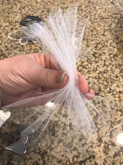 Hey Hometalk! If you're looking for a Christmas ornament idea that is super easy to make, this one is for you! I love angels and this one will be put on my tree.        First take some tulle and fold it like an accordion. Then tie a string at the top. You can use some scissors to straighten out the edges.    The next thing I did was cut a cap off of the ornament.    Then I glued the cap to a wooden bead.    It'll look like this!    Then glued the white bead to the top- it's the angel… Angels Made With Tulle, Tulle Christmas Angels, No Sew Angel Ornament, Angels To Make For Christmas, Diy Tulle Angel Ornaments, Angels Diy Christmas, Easy Angels To Make, Christmas Diy Angles, Tulle Angel Ornaments