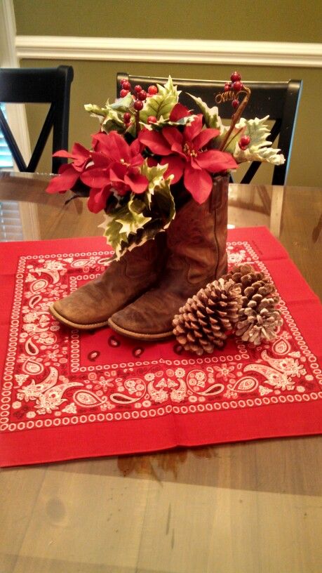 Cowboy Christmas boot centerpiece Texas Themed Christmas Decorations, Western Xmas Decor, Cowboy Boot Christmas Decor, Cowboy Christmas Table Decorations, Christmas Western Decorations, Christmas Western Decor, Cowboy Themed Christmas Party, Western Christmas Centerpiece Ideas, Cowboy Christmas Centerpieces