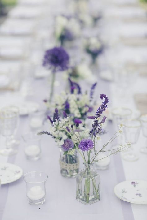 Purple Chiffon Table Runner, Purple Simple Centerpieces, Lilac Wedding Flowers Table, Purple Flower Table Decorations, Rustic Spring Wedding Centerpieces, Houseplant Wedding Table Decor, Lavender And Eucalyptus Wedding Centerpieces, Lavender And Silver Table Setting, Lavender Flower Wedding Decor