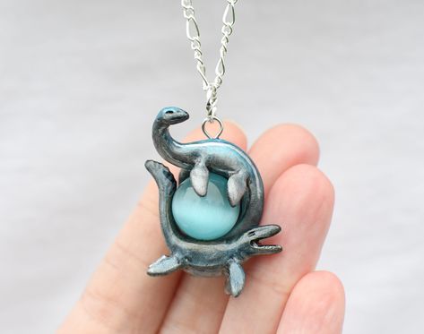 A perfect gift for yourself or the prehistoric marine reptile lover in your life! This cute mosa and plesiosaur duo necklace measures measures 1.55x1.25 inch. This pendant was originally sculpted from polymer clay, then cast in resin. From there it is hand painted and finished with a durable sealant so it won't break or scratch with daily wear. **NOTE** Your order is made to order and is unique, so it will vary slightly from the example shown in the pictures due to the hand painting process. If you would like a picture of your piece before shipping I can send you one, just send me a message. Reptile Jewelry, Duo Necklace, Colored Gems, Hand Painting, Painting Process, Clay Projects, Clay Art, Clay Jewelry, Reptiles