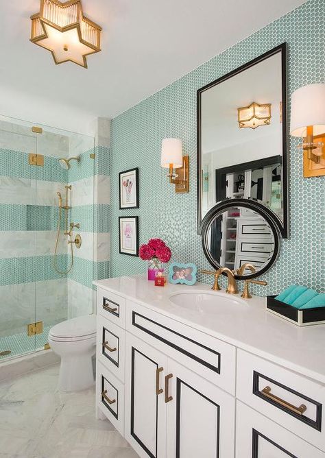 White herringbone marble tiles cover the floors of this exquisite contemporary bathroom featuring a white and black washstand accented with brass pulls and an aged brass faucet topped with a white quartz countertop placed under an upside down black framed mirror illuminated by a Sophia Small Flush Mount and brass sconces mounted to a wall covered in turquoise penny tiles. Kate Spade Bedroom, Teenage Bathroom, Ibb Design, Girl Bathroom Decor, Teen Bathrooms, Toilette Design, Penny Tile, Dekorasi Kamar Tidur, Girls Bathroom