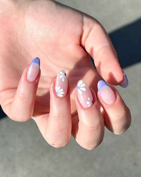 Show your girly side with a touch of elegance like this nail art we made here! The delicate nude pink base with purple French tips, adorned with charming daisy flower art, creates a look that's both sweet and sophisticated. It's like having a beautiful spring day right at your fingertips! 🌼💅💜 . . #NudePinkNails #PurpleFrenchTips #DaisyNailArt #SeattleNailSalon #ElegantNailArt #GirlyNailDesign #FloralNails #ChicNails #NailArtLovers #NailFashion #NailArtInspiration #NailArtAddict #NailGoals White Acrylic Nails With Purple Flowers, Pink And Purple Tips Nails, French Tip Nails Lavender, Purple French Tips With Flowers, Blue Lavender Nails, Nails To Match Purple Dress, Cute Light Purple Nails, Purple Flower Nail Designs, Purple Nails Flower