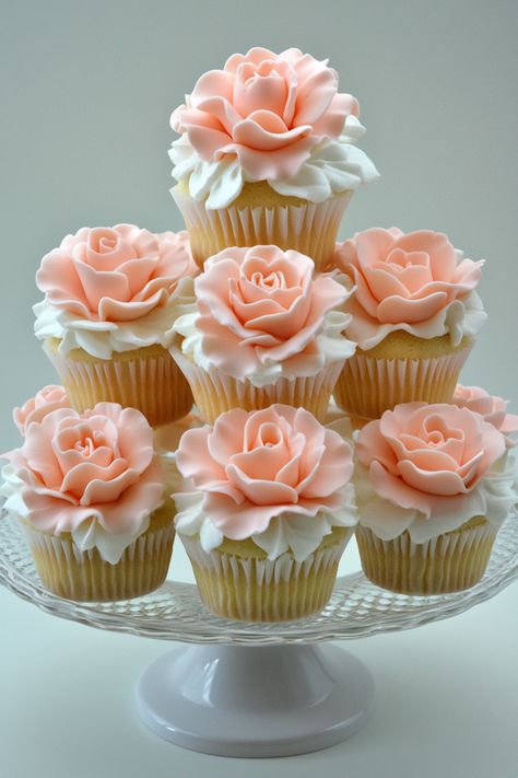 Wedding dessert display. Pink marzipan roses, white petal drapings on gourmet cupcakes.  Your wedding cake is so much more than just a dessert. It's a centerpiece, a cherished tradition, and let's face it, a divine Instagram opportunity. Choosing the right floral arrangement to enhance your cake can elevate its aesthetic from nice to truly unforgettable. If you're pondering about the perfect bloom…  Read more: https://tastywed.com/generated-post-28-innovative-wedding-cake-flower-arrangement-ideas/ Cupcake Display Ideas Wedding, Pink Flower Cupcakes, Wedding Dress Cupcake Cake, Wedding Dessert Display, Wedding Cake Flower, Wedding Dress Cupcakes, Wedding Cupcake Display, Dessert Display Wedding, Spring Cupcakes