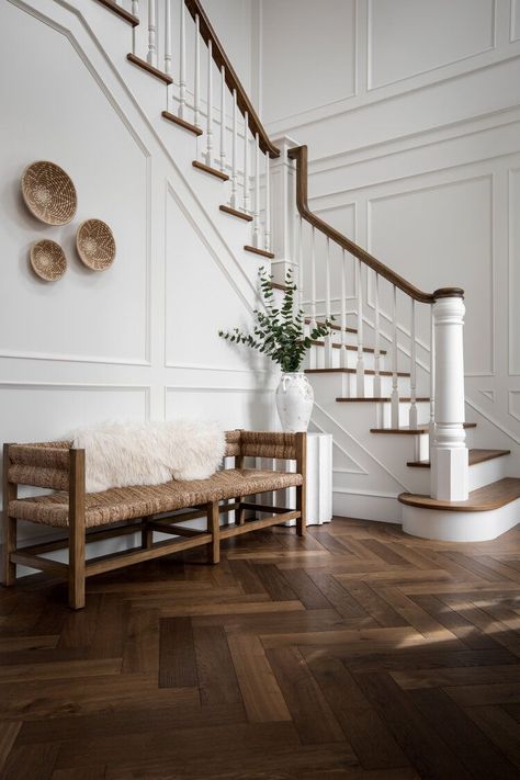 A classy entryway basking in elegant finishes of herringbone wood floors and white wainscoting walls! + herringbone floor + white wainscoting + elegant staircase + entryway bench + traditional stairwell | Design by Jenny Martin Design Updated Colonial Interior, French Inspired Master Suite, Base Of Stairs Decor Entryway, French Country Design, Stair Case, French Architecture, Herringbone Floor, Entry Hallway, Victoria Park