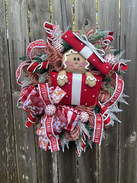 No Peeking! This adorable gingie peeking out of the present is ready to tantalize everyone that comes to your home . This amazing wreath will bring your front door in the spotlight for the holiday season. Grab her now before you miss out. A very special shout out to Alex, owner of Shop.viure she made this adorable gingie in the present attachment . ❤️ Link to purchase in the comments Christmas Ornaments Wreath, Pink Gingerbread House, Ornaments Wreath, Gingerbread Wreath, Square Wreath, Pink Gingerbread, No Peeking, Christmas Ornament Wreath, Gingerbread Christmas